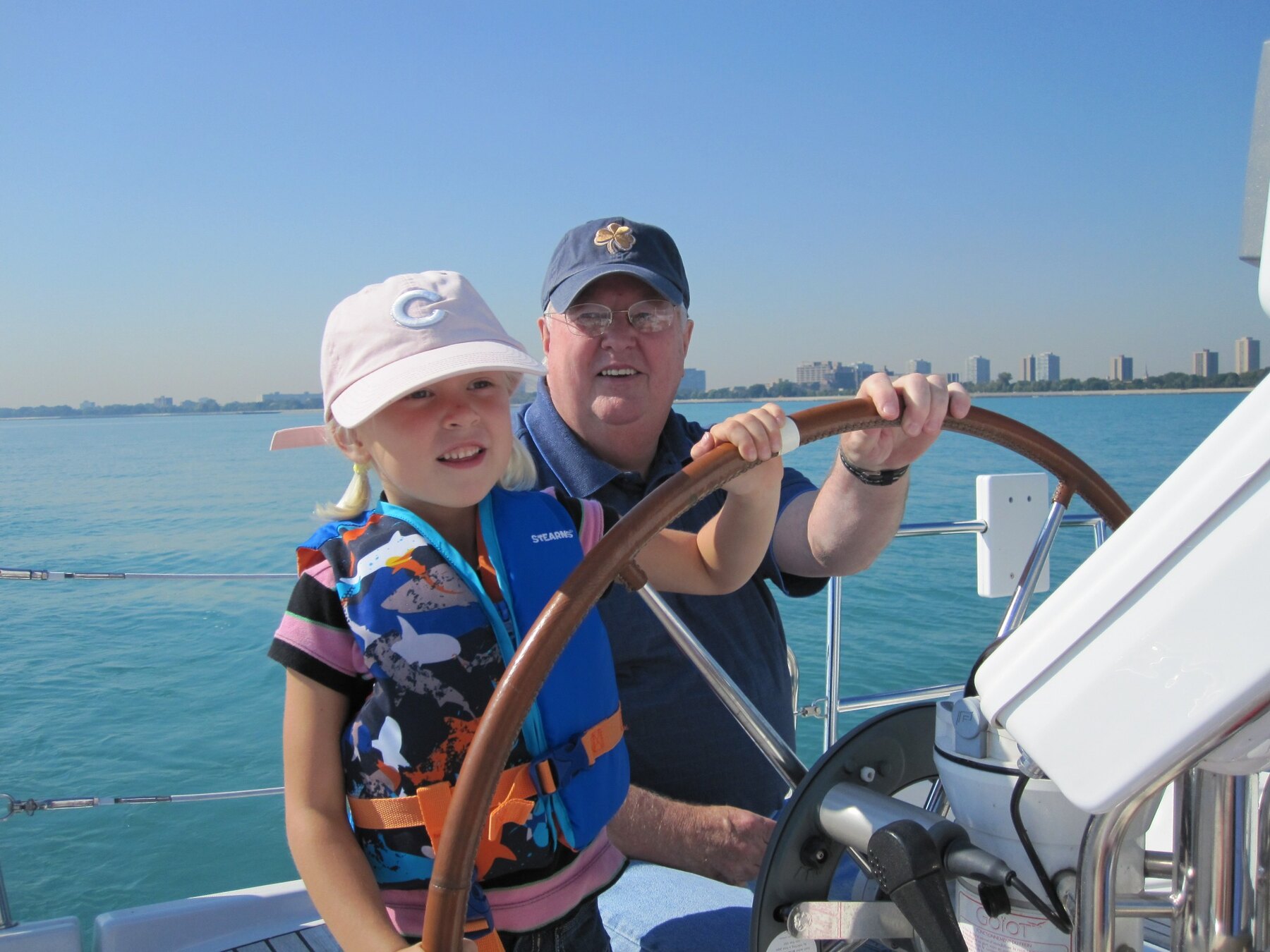 Tom Snyder helping a young family member steer a boat